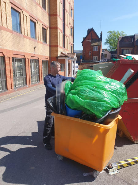 Man With Van Loading Waste into a Skip for Recycling